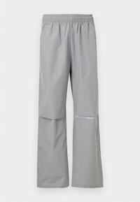 Αδιάβροχο παντελόνι βροχής ανοιχτού γκρι με ελαστική μέση και αντανακλαστική λωρίδα στο δεξί πόδι, σχεδιασμένο για υπαίθρια χρήση.