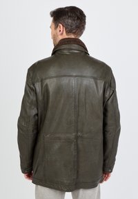 Olivegrüne Lederjacke mit einem braunen, strukturierten Kragen, legere Passform und sichtbaren Nähten auf der Rückseite. Glatte, leicht glänzende Textur.