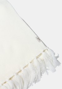 Sciarpa bianca lavorata a maglia con dettagli in frange lungo il bordo inferiore e una piccola etichetta nell'angolo, realizzata in materiale morbido.