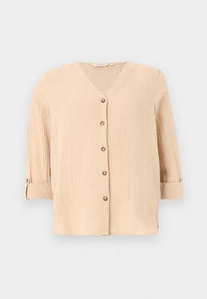 Μπεζ μπλούζα με υφή, V-λαιμόκοψη, πέντε κουμπιά μπροστά και μανίκια 3/4 που είναι διπλωμένα και στερεωμένα με λωρίδα με κουμπί.