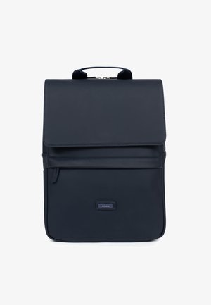 Navy blue backpack with a smooth synthetic exterior, top handle, flap closure, front zip pocket, and a rectangular shape. Brand label visible.