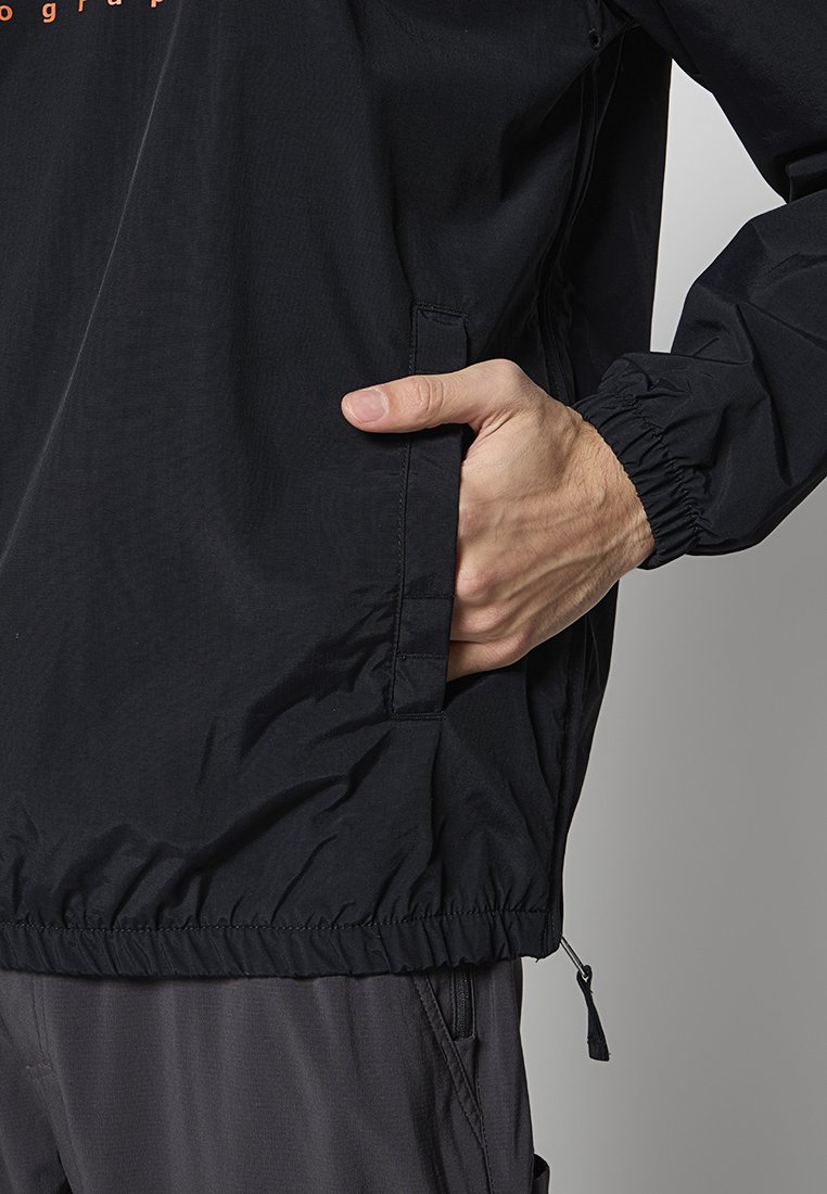 Zwarte lichtgewicht jas met elastische manchetten, zijzakken en een trekkoord aan de onderkant. Het materiaal lijkt soepel met een subtiele glans.