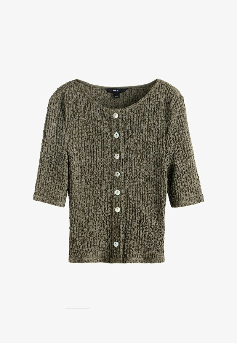 Cardigan en maille texturée vert olive avec sept boutons blancs, col rond et manches trois-quarts sur fond blanc.