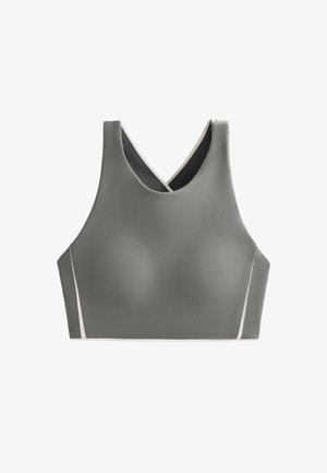 Harjoitusliivi harmaasta kankaasta, jossa on sileä pinta. V-mallinen kaula-aukko ja kevyet accenttiviivat reunoilla.