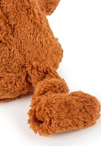 Plush brown teddy bear's arm and paw with soft, textured fur against a white background, showing detailed fabric fibers.