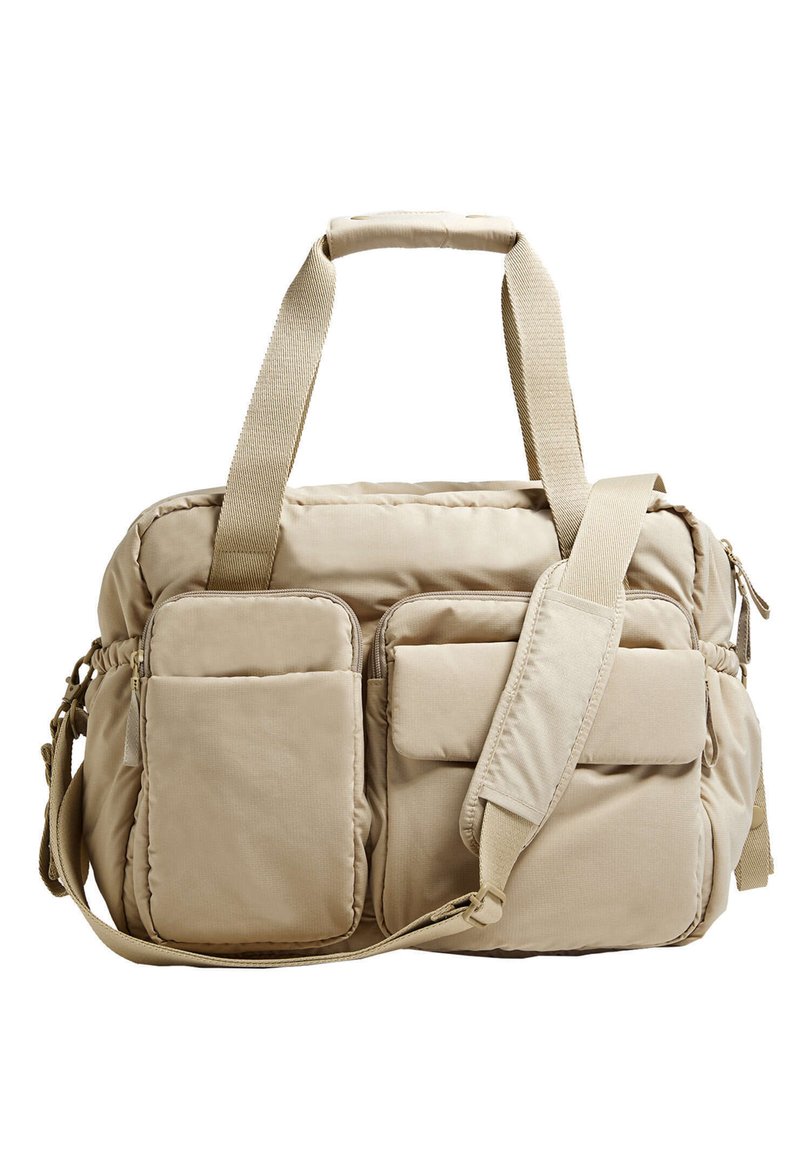 Borsa imbottita beige con doppi manici superiori, tracolla regolabile e molteplici tasche con zip sulla parte anteriore e sui lati. Tessuto testurizzato.