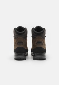 Bruine en zwarte wandelschoenen met een gevulde kraag, textuurvariaties en een robuuste zool. Kenmerkt duurzame materialen en subtiele hardwaredetails.