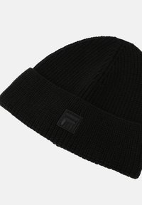 Beanie nero a maglia con texture a coste e bordo ripiegato. Presenta un'etichetta con logo nera sul fronte per il branding. Materiale morbido e flessibile.