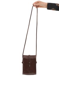 Brązowa skórzana torba na ramię o gładkiej fakturze, prostokątnym kształcie, regulowanym pasku i zamknięciu na klapkę z przodu.