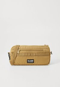 Rjava pravokotna torbica čez ramo z zunanjim žepom z zadrgo spredaj, nastavljivim trakom in oznako blagovne znamke Palladium na belem ozadju.