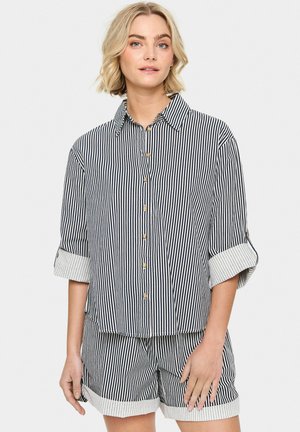 Striped shirt and shorts set in navy and white. Features a collared neckline, buttons, and rolled sleeves with a contrasting stripe pattern.