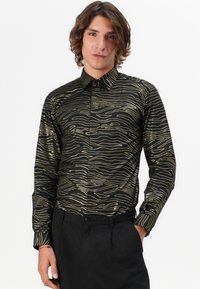 Schwarzes Hemd mit goldener Wellenlinienmuster, langen Ärmeln, spitzen Kragen und Knopfleiste, kombiniert mit schwarzen Hosen.
