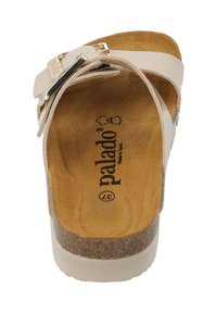 Sandal beige chiaro con soletta piatta in sughero, una fascia ampia e una fibbia argentata sulla parte superiore. Internamente presenta una texture morbida simile al suede.