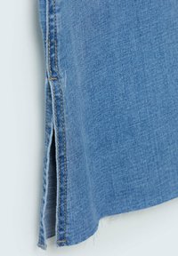 Lichtblauwe denim rok met een onafgewerkte zoom, zijsplitten en contrasterende stiksels langs de naden voor extra detail.