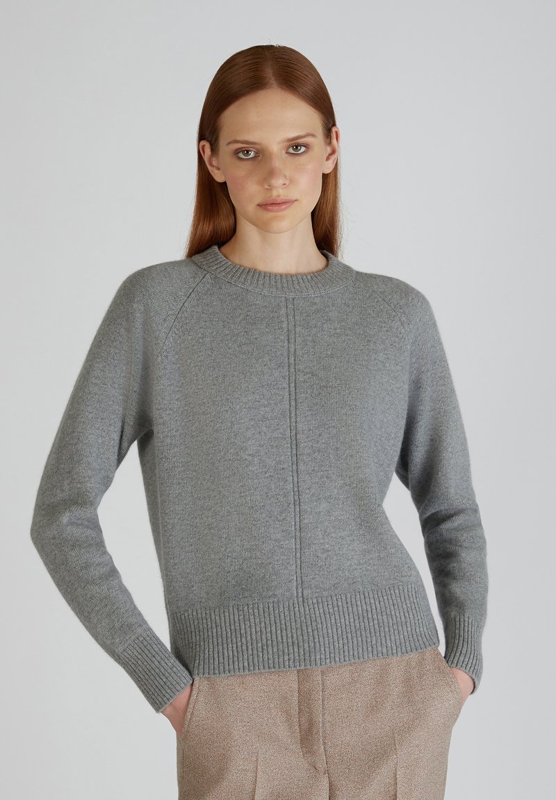 Maglione grigio a maglia con scollo a girocollo a coste, maniche raglan e finitura testurizzata. Il design include una cucitura centrale e orlo aderente.