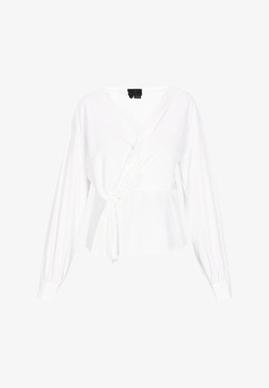 Top alb cu mâneci lungi, prezentând un detaliu cu fundă la talie și o textură netedă. Designul cu decolteu în V accentuează linia gâtului.