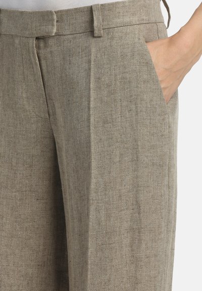 Hlače od lanenog materijala boje kakija imaju teksturiranu tkaninu, kroj po mjeri, prednje džepove i oštar pojas s nježnim nabranim detaljem.