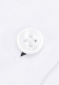 Biała tkanina o wzorze w herringbone oraz okrągły, biały guzik z czterema otworami z wytłoczonym napisem "PROČHNIK" na powierzchni.