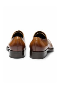 Brown leather dress shoes with a smooth finish, rounded toe, and low stacked heel. The interior features a contrasting tan lining.