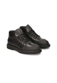 Botas negras de cuero hasta el tobillo con parte superior texturizada, puntera lisa, sistema de cordones entrelazados y ganchos metálicos. Suela de goma para tracción.