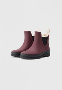 Bottines imperméables en caoutchouc bordeaux avec des semelles noires, des panneaux latéraux élastiques et des tirettes de couleur crème. Intérieur en polaire.