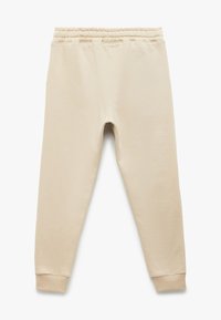 Ljust beige sweatpants tillverkade av mjukt tyg, med resår i midjan och ribbade muddar vid anklarna. Slät, minimalistisk design.
