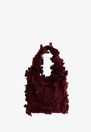 Sac fourre-tout en tissu bordeaux avec des appliqués floraux 3D couvrant toute la surface et des anses larges et rembourrées.