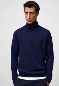 Klassischer Dunkelblauer Rollkragenpullover aus weichem Strickmaterial, versehen mit langen Ärmeln, einem figurbetonten Schnitt und minimalen Nähten auf der Vorderseite.