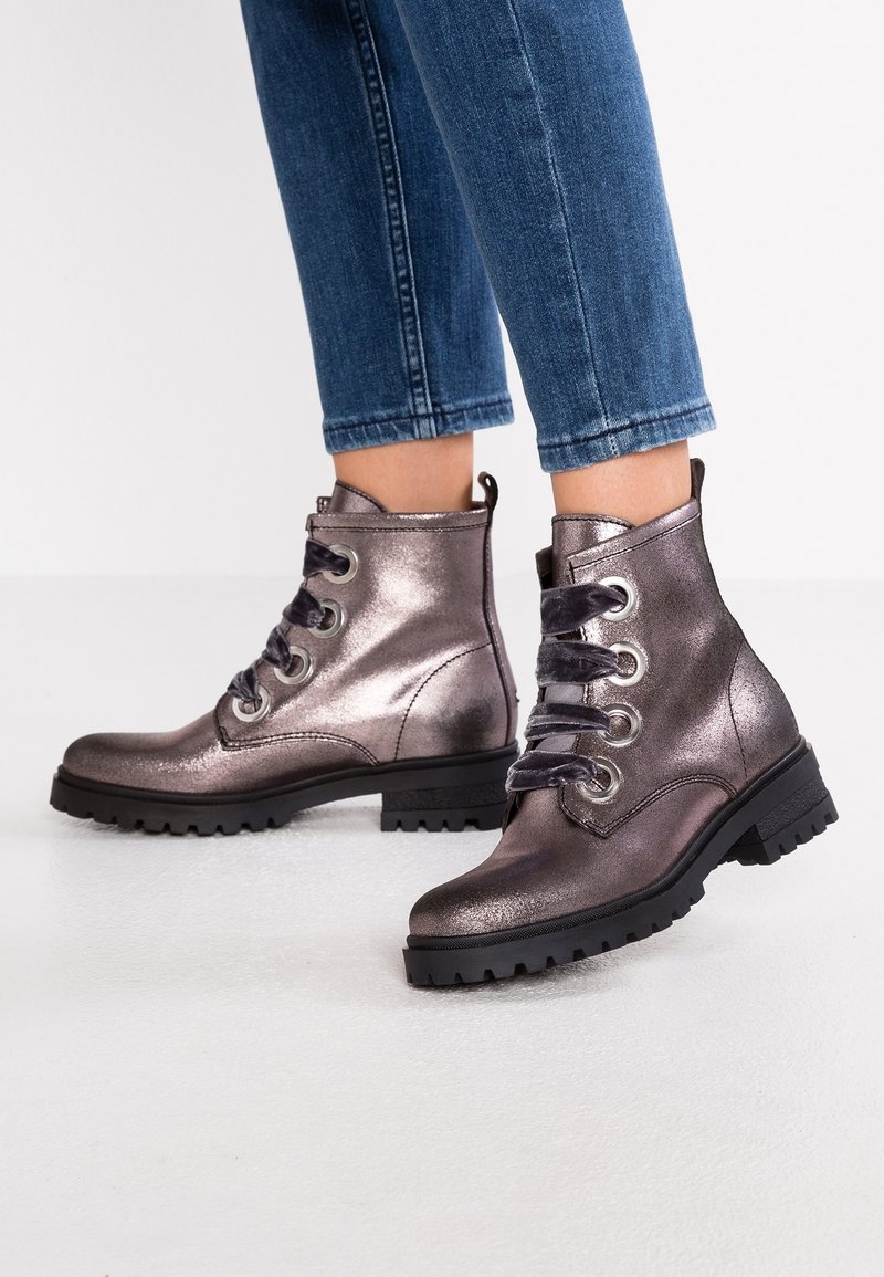 Bottines gris métallisé avec un bout arrondi, semelle crantée noire et lacets décoratifs. Présente des œillets en métal argenté et des lacets en tissu.