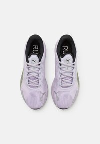 Baskets de sport d'un violet clair avec une tige en maillage texturé, des lacets fins et des accents réfléchissants. Intérieur noir et logo sur la languette. Design léger.