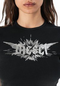 Black ribbed short-sleeve top featuring a silver graphic print with the word "Diesel" and burst design. Rounded neckline and fitted shape.