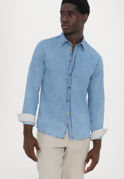 Light blue denim shirt with a button-down collar, colorful buttons down the front, and striped cuffs. Smooth texture and relaxed fit.