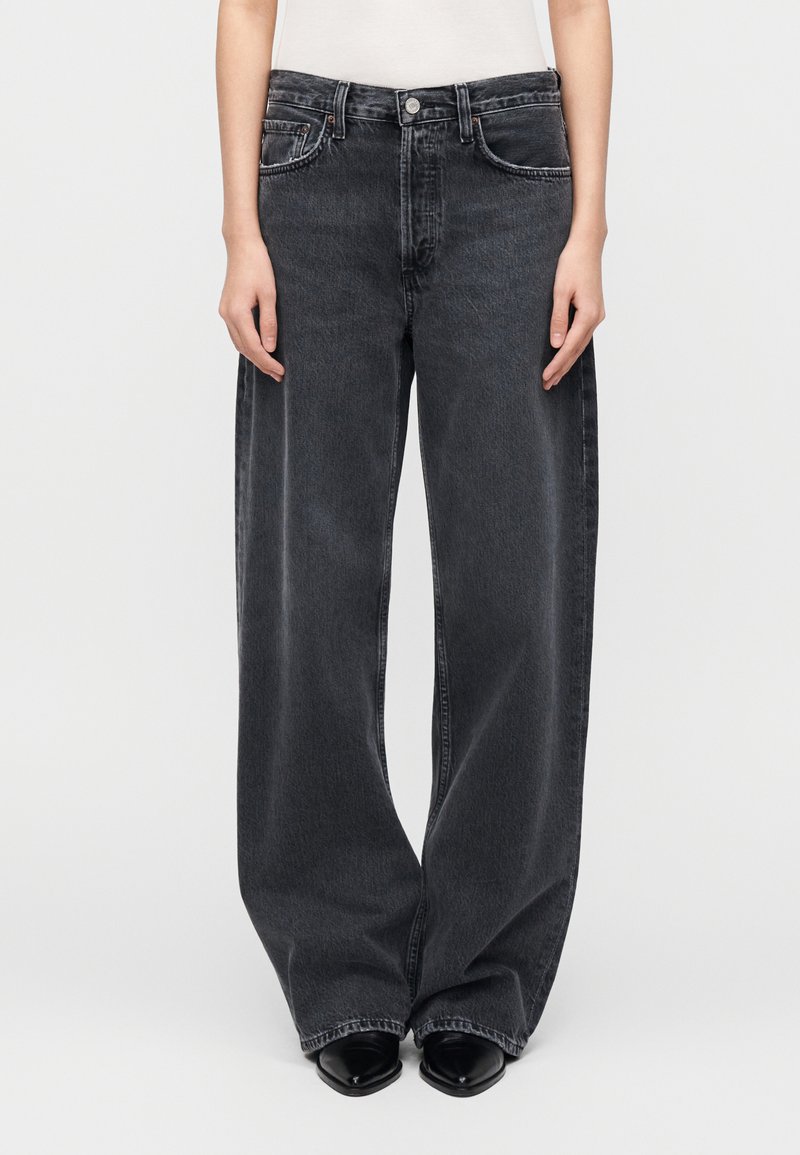 Μαύρο τζιν φαρδιάς γραμμής κατασκευασμένο από denim. Διαθέτει ψηλή μέση, σχεδιασμό με πέντε τσέπες και απαλή ξεθώριαση κατά μήκος του μπροστινού μέρους.