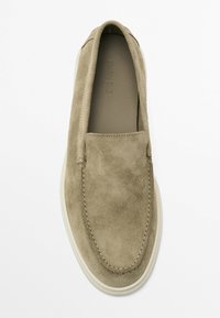 Suede slip-on shoe in light olive green with a smooth texture and contrasting white rubber sole. Features discreet stitching along the edges.