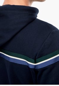 Felpa con cappuccio in tessuto blu navy. Caratterizzata da dettagli a righe verdi, blu e bianche sulle spalle. Tessuto morbido.