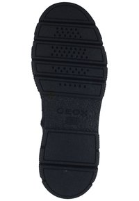 Black rubber shoe sole with textured surfaces and grooves for traction. Features a perforated design for breathability and includes branding.