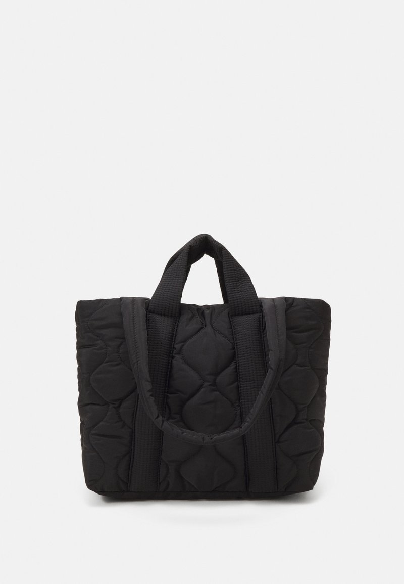 Sac cabas matelassé noir avec deux petites poignées et texture rembourrée, debout sur un fond blanc uni.