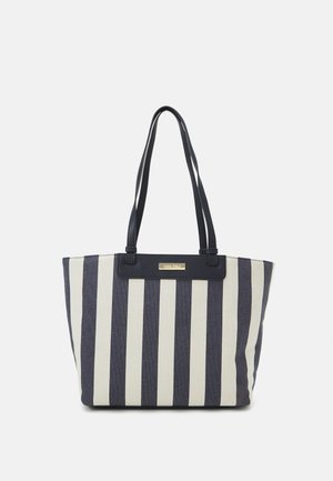 Striped tote bag in navy and cream with textured fabric, dual shoulder straps, and a front logo plaque. Structured design with ample space.