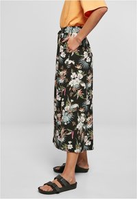 Svart blomstermønstret midi-skjørt med elastisk midje, som har tropiske trykk i pastellfarger, sidelommer og en avslappet passform.