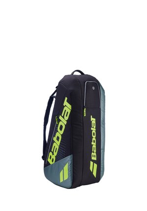 Zwart- en grijze Babolat sporttas met neon gele logo's en ritsen, voorzien van schouderbanden en meerdere met rits afsluitbare compartimenten.