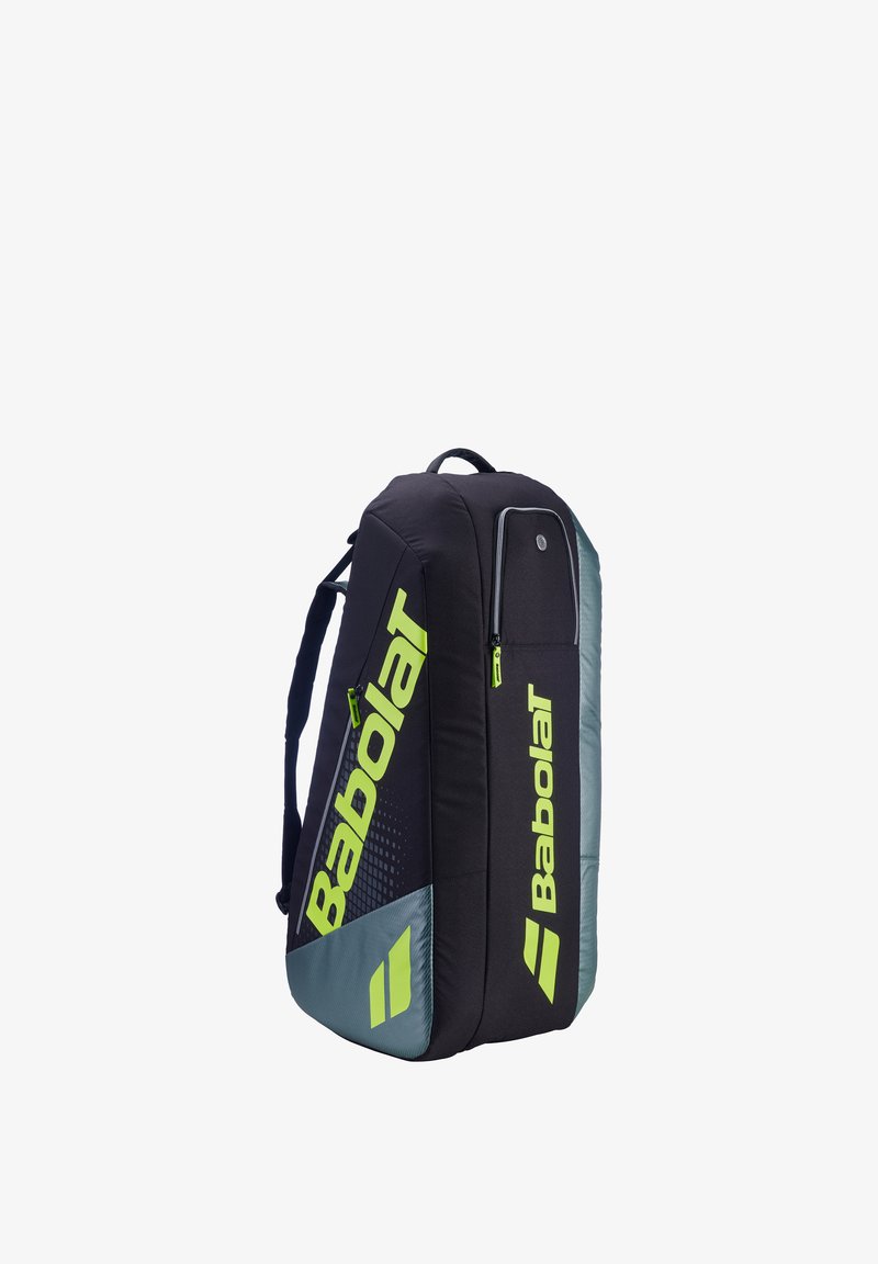 Zwart- en grijze Babolat sporttas met neon gele logo's en ritsen, voorzien van schouderbanden en meerdere met rits afsluitbare compartimenten.