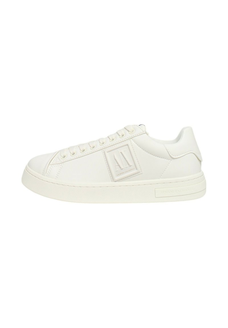 Sneaker bianca in pelle con superficie texture, punta rotonda, suola piatta e design minimalista con una placca logo sul lato.