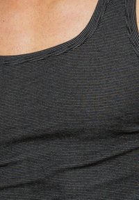 Canotta nera con righe orizzontali grigie e bianche. Presenta una scollatura rotonda e un tessuto morbido e strutturato.