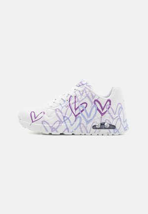 Weißer Sneaker mit lila und blauen Herzmustern, Obermaterial aus Mesh, gepolsterte Sohle und sichtbarem Air-Element. Schnürdesign mit perforierten Akzenten.