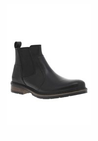 Bota de ankle de cuero negro con paneles elásticos a los lados, punta redondeada y suela de goma marrón. Cuenta con una lengüeta para facilitar el calzado.