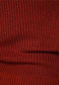 Dzianina o głębokim czerwonym kolorze, prezentująca teksturowany wzór z prążkowanymi fragmentami, tworząc jednolity wygląd na całej powierzchni.