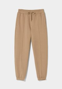 Beige Jogginghosen aus weichem Stoff, mit einem elastischen Taillenbund und Kordelzug, seitlichen Taschen und elastischen Bündchen an den Knöcheln.