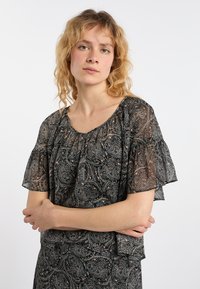 Černá blůza s paisley vzorem a krátkými volánkovými rukávy, vyrobená z lehkého materiálu, s kulatým výstřihem a jemným leskem.