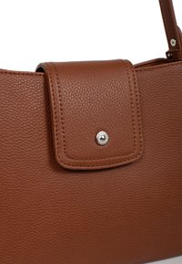 Brązowa skórzana torebka o teksturowanej powierzchni, z klapą zamykaną na srebrny zatrzask. Prosty, prostokątny kształt.