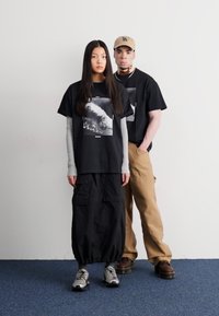 Salomon ALL THAT RIDEZ TEE UNISEX - Μπλουζάκι με στάμπα - deep black